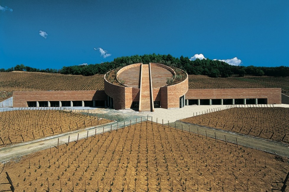 Находится в самом центре виноградников Тосканы. Владелец Витторио Моретти пригласил известного архитектора Марио Ботта (автора Музея современного искусства в Сан-Франциско).